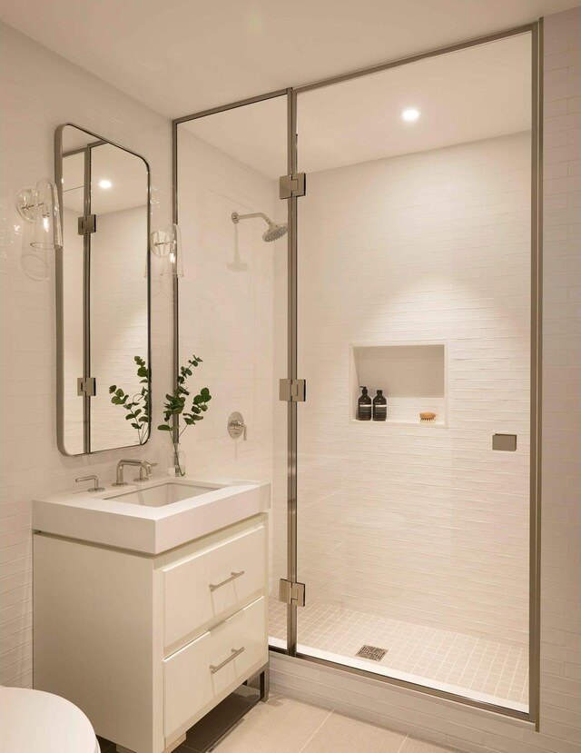 bathroom with toilet, a stall shower, and vanity