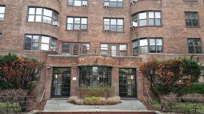 entrance to property featuring cooling unit and brick siding