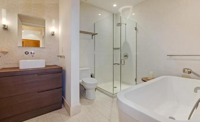 full bathroom featuring vanity, tile patterned flooring, toilet, and separate shower and tub