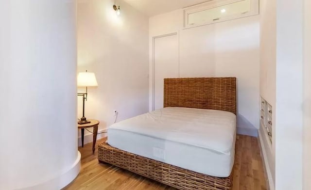 bedroom with light wood-type flooring and baseboards