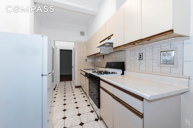 kitchen featuring light countertops, white appliances, under cabinet range hood, and white cabinets