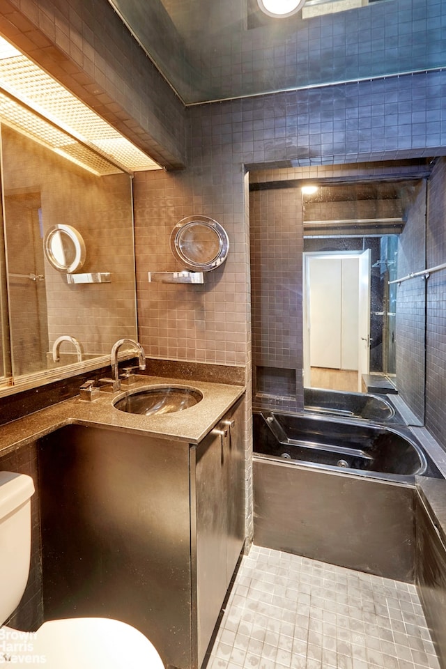 full bathroom with a bathing tub, toilet, vanity, and decorative backsplash