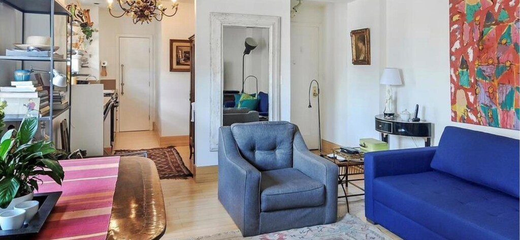 living room with light hardwood / wood-style flooring and a notable chandelier