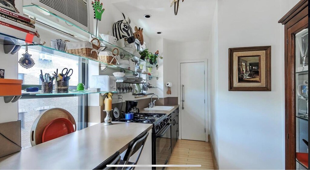 kitchen featuring sink, black gas stove, and light hardwood / wood-style floors