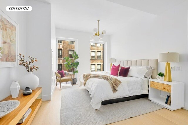 bedroom with an inviting chandelier, hardwood / wood-style flooring, and vaulted ceiling