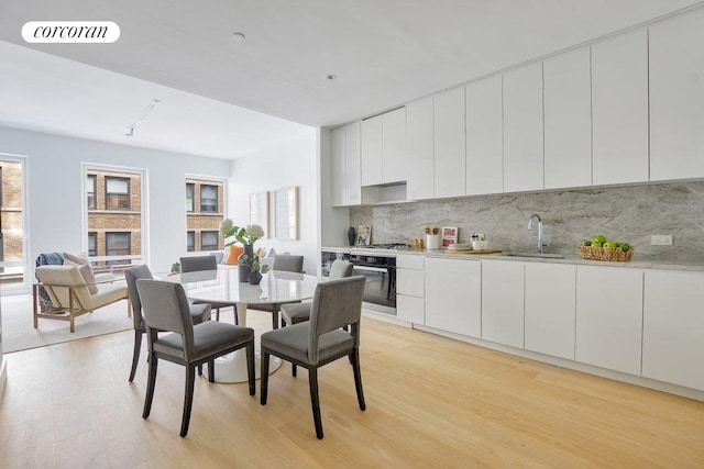 dining area featuring sink and light hardwood / wood-style flooring