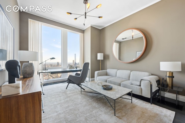 living room with baseboards, a notable chandelier, and wood finished floors