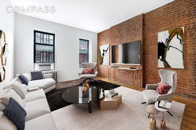 living room featuring radiator, brick wall, cooling unit, and wood-type flooring