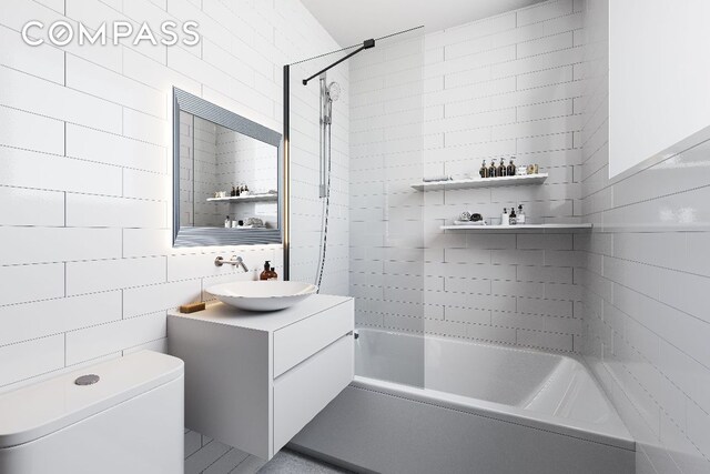 full bathroom featuring toilet, tile walls, tiled shower / bath, and vanity