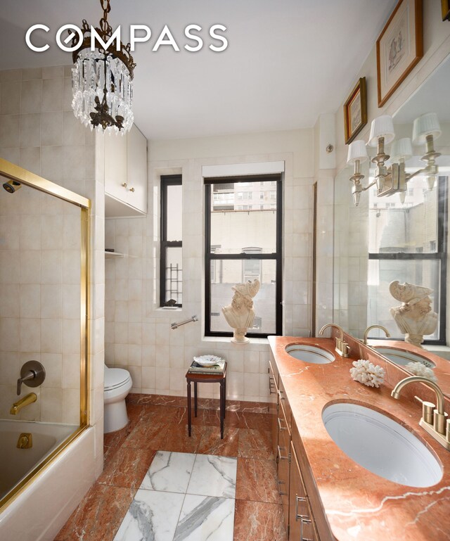 kitchen with washer / dryer, backsplash, a chandelier, black appliances, and sink