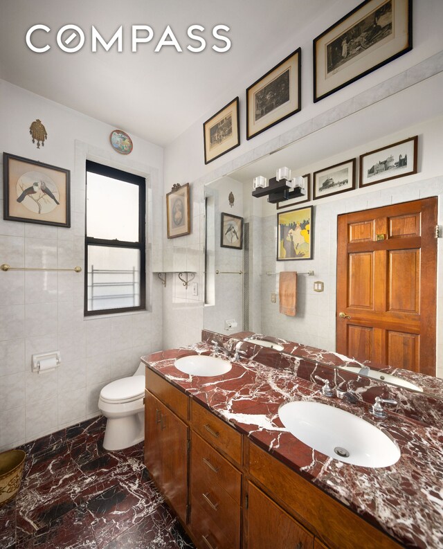 full bathroom with enclosed tub / shower combo, vanity, tile walls, toilet, and a chandelier