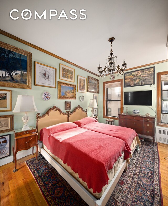 living room featuring a chandelier, ornamental molding, and wood-type flooring