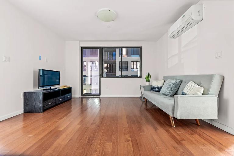 sitting room with hardwood / wood-style floors and a wall mounted AC