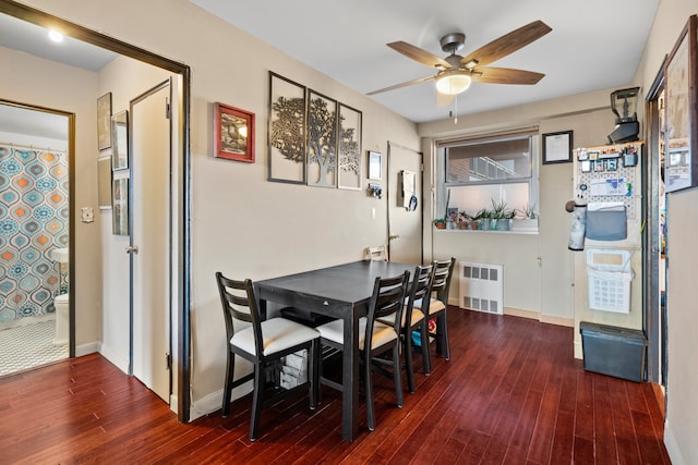 dining room featuring baseboards, ceiling fan, radiator heating unit, and wood finished floors