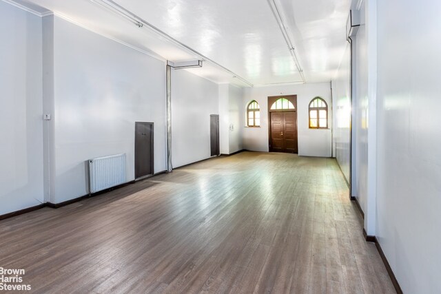 interior space with light wood-type flooring and radiator heating unit