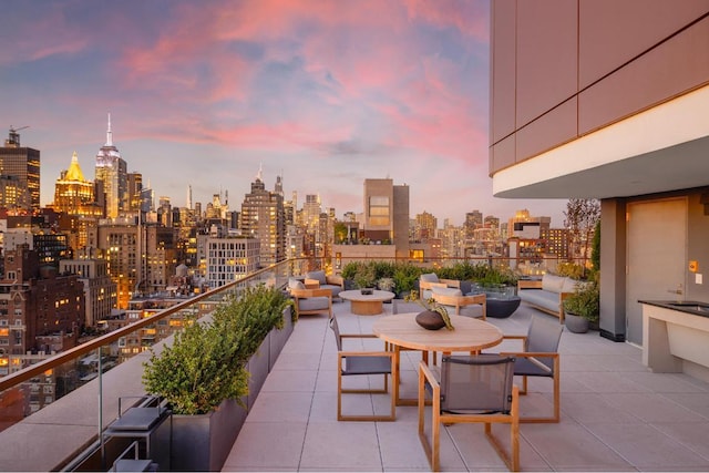 patio terrace at dusk featuring a balcony