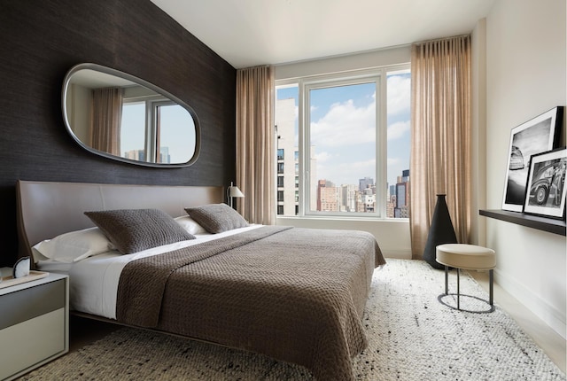 bedroom featuring baseboards and a city view