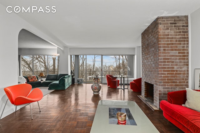 4455 Douglas Ave Unit 3Ef, New York City, NY 10471 - living area featuring plenty of natural light, a brick fireplace, arched walkways, and wood finished floors