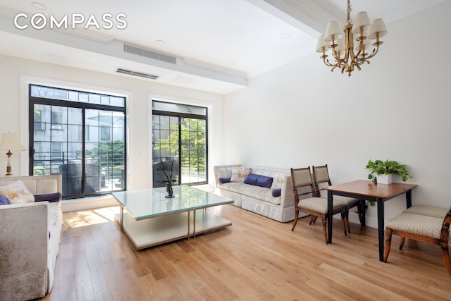 living room featuring a chandelier, visible vents, light wood-type flooring, and ornamental molding