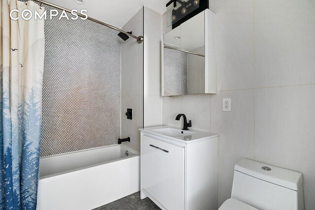 bathroom with toilet, shower / bath combo with shower curtain, vanity, and tile walls