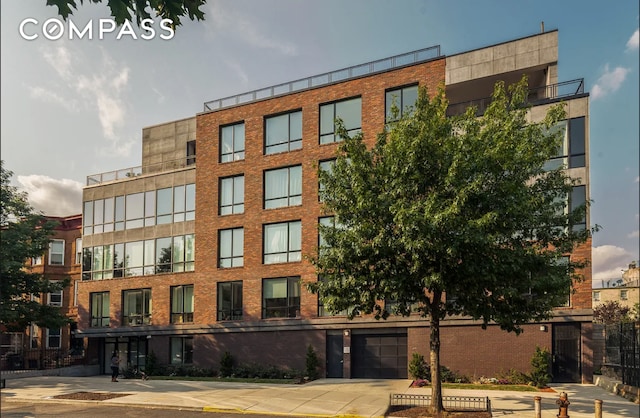 1325 Herkimer St Unit 302, New York City, NY 11233 - view of apartment building / complex featuring concrete driveway and a garage