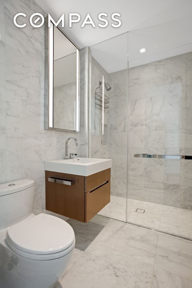 bathroom with toilet, marble finish floor, a walk in shower, and vanity