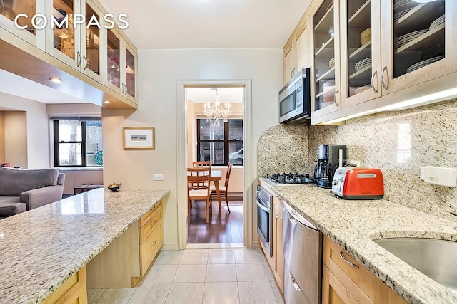 50 Sutton Pl S Unit 2D, New York City, NY 10022 - kitchen with stainless steel appliances, light brown cabinets, and decorative backsplash