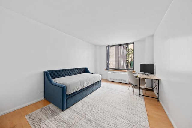 bedroom featuring radiator heating unit and hardwood / wood-style floors