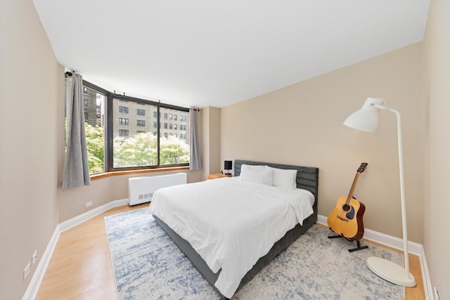 bedroom with radiator and hardwood / wood-style flooring