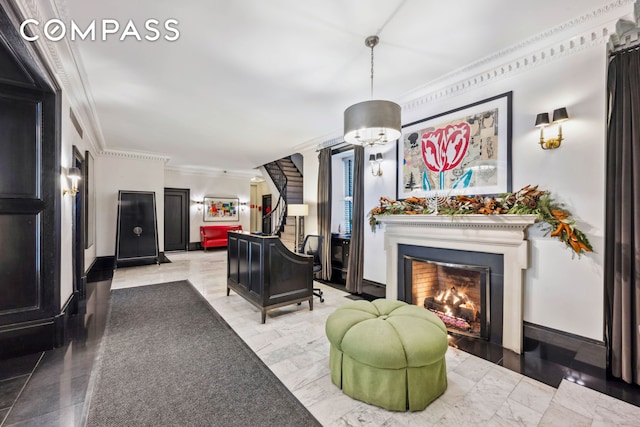 living area featuring stairs, a lit fireplace, ornamental molding, and baseboards