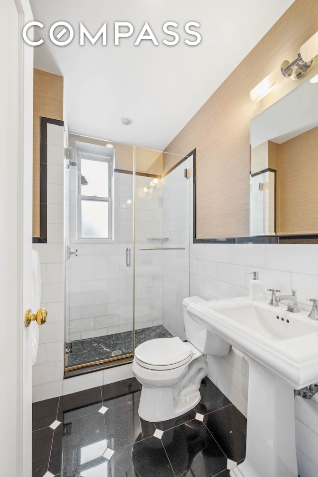 25 5th Ave Unit 6C, New York City, NY 10003 - full bathroom with toilet, tile walls, a shower stall, granite floors, and a sink