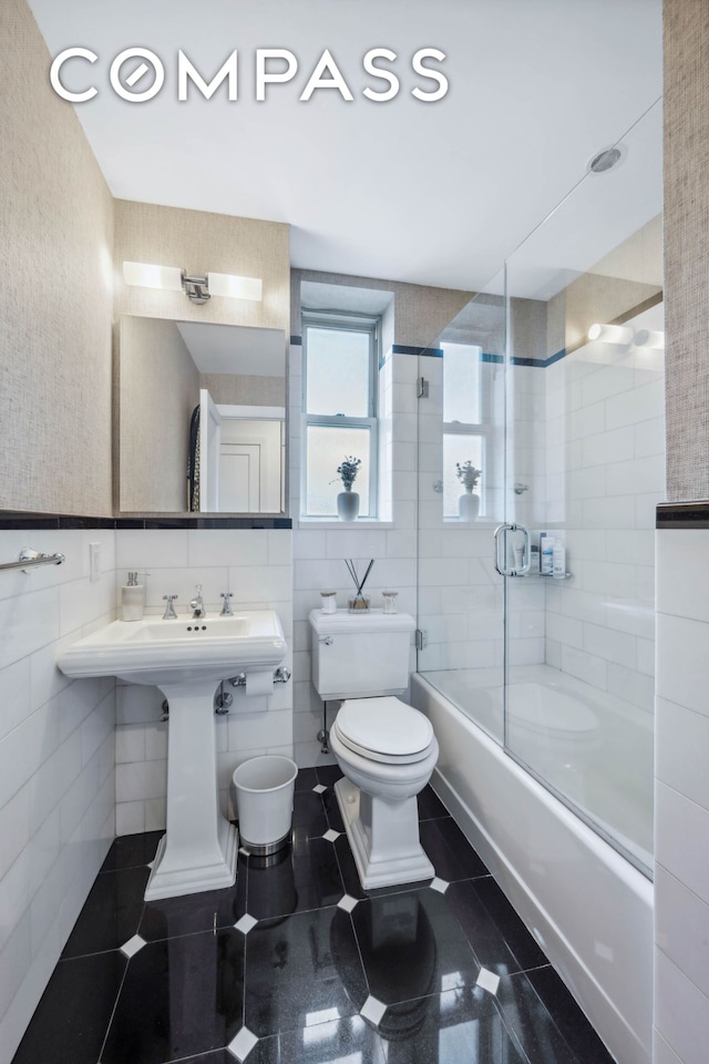 full bathroom with enclosed tub / shower combo, toilet, tile walls, tile patterned floors, and wallpapered walls