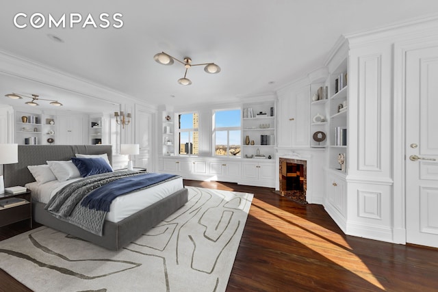 bedroom with a premium fireplace, dark wood-style floors, and ornamental molding