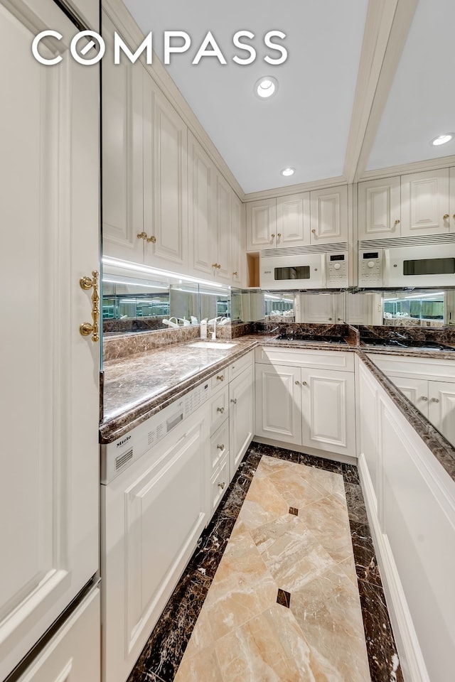 kitchen with recessed lighting, white appliances, and white cabinets