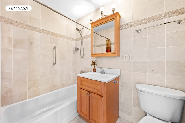 bathroom with tile walls, tub / shower combination, vanity, and toilet