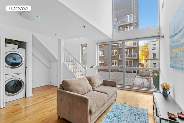 living room featuring a wealth of natural light, visible vents, wood finished floors, and stacked washer and dryer