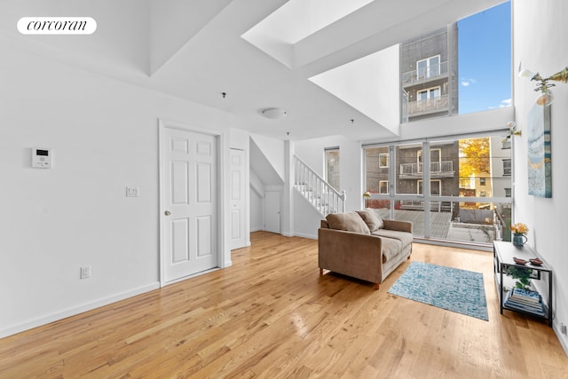 living area with visible vents, baseboards, wood finished floors, and stairs