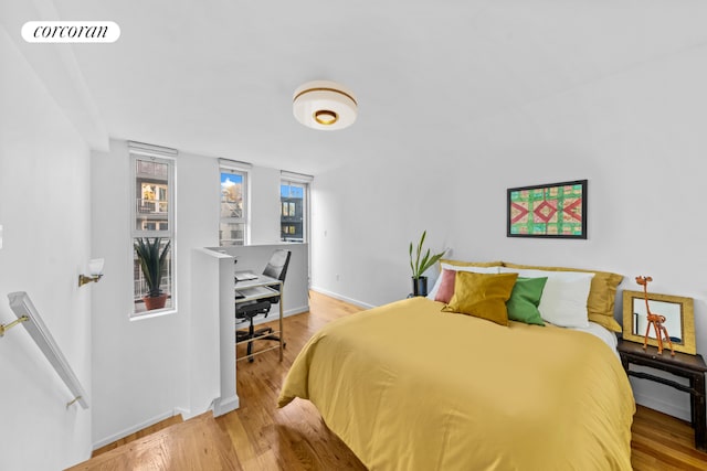 bedroom featuring baseboards, visible vents, and wood finished floors