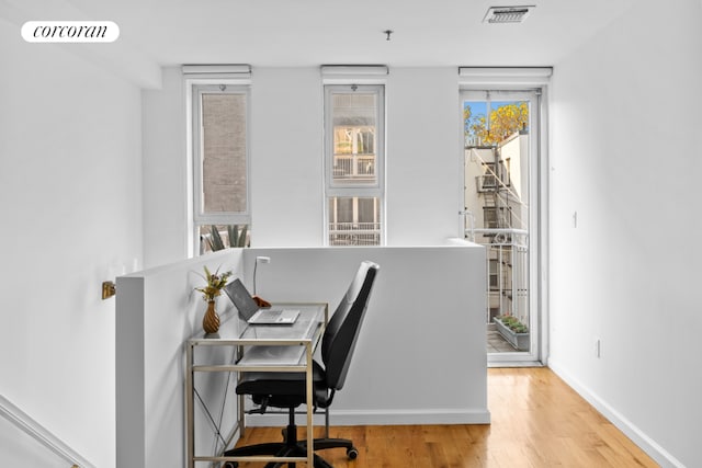 home office with visible vents, baseboards, and wood finished floors