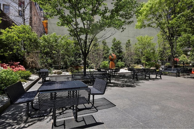 view of property's community featuring fence and a patio