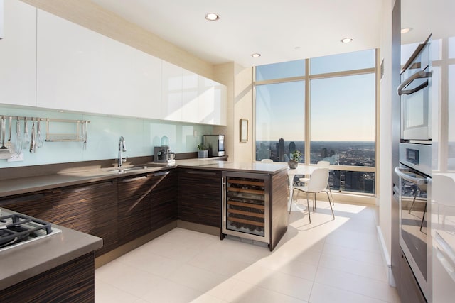 kitchen with wine cooler, modern cabinets, and white cabinetry