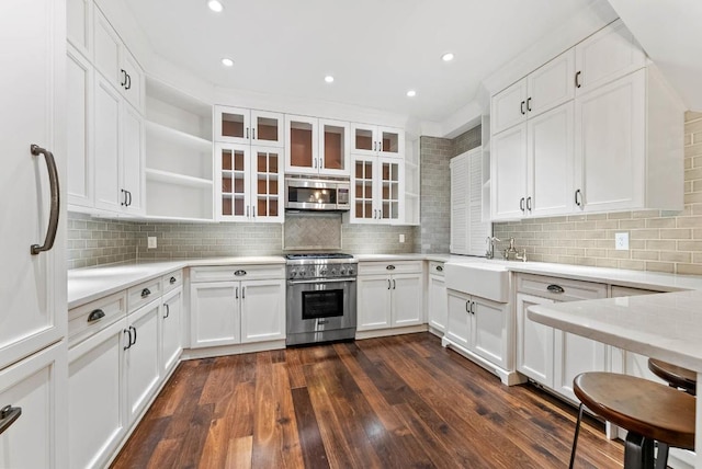 kitchen with dark wood-type flooring, stainless steel appliances, sink, and white cabinets