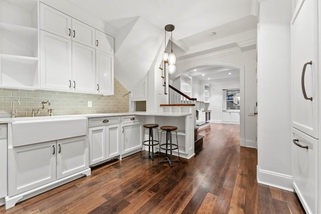 kitchen with open shelves, pendant lighting, white cabinets, and a sink