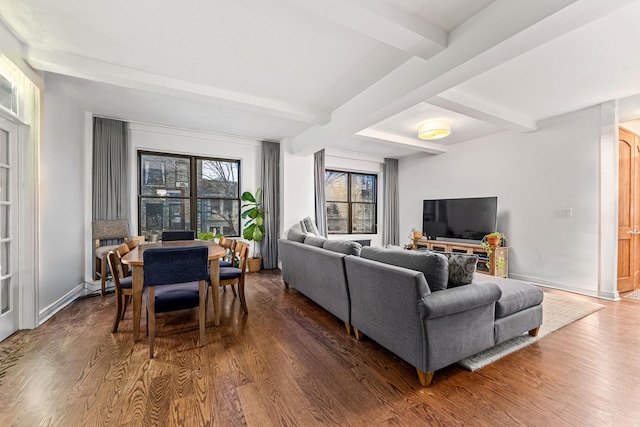 living area with beam ceiling, baseboards, and wood finished floors