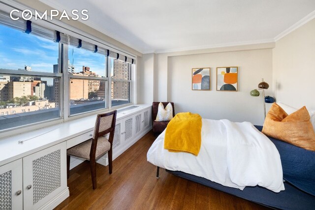 bedroom with dark hardwood / wood-style floors and ornamental molding