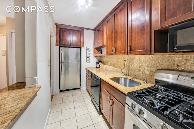 kitchen with light stone counters, sink, tasteful backsplash, and black appliances