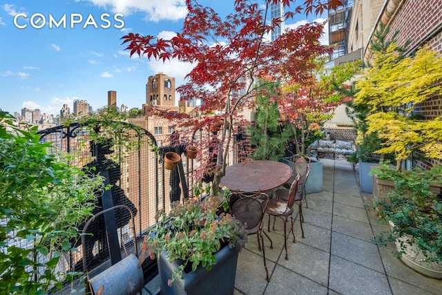 view of patio / terrace featuring outdoor dining area and a city view