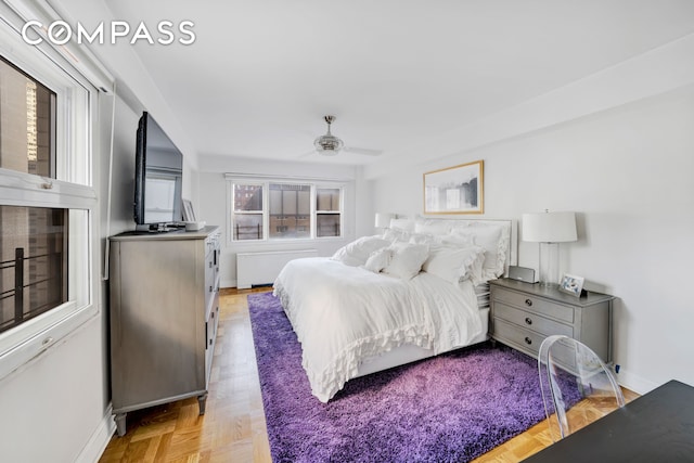 bedroom featuring radiator heating unit, baseboards, and ceiling fan