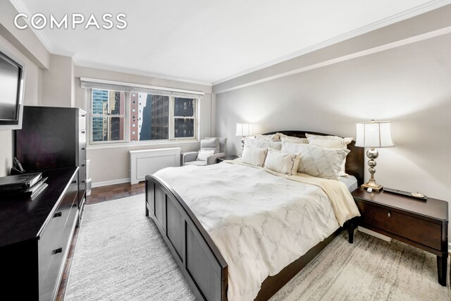 bedroom with crown molding and light hardwood / wood-style flooring