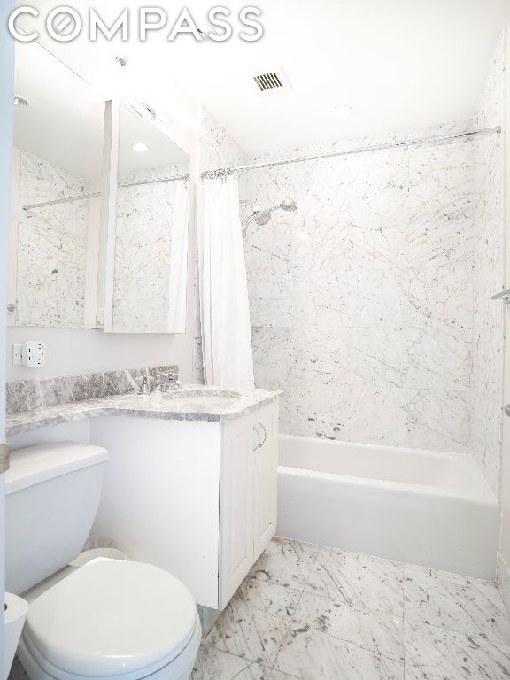 full bathroom with toilet, shower / bathtub combination with curtain, and vanity